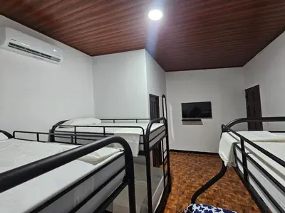 a room with four bunk beds and a tv at Hotel Luna Liberiana in Liberia