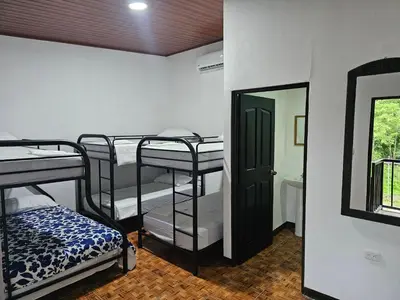 a room with three bunk beds and a mirror at Hotel Luna Liberiana in Liberia