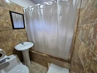 a bathroom with a toilet and a sink and a shower at Hotel Luna Liberiana in Liberia