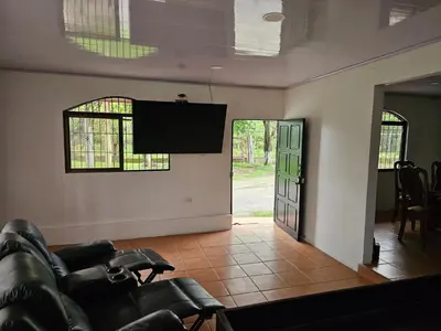 a living room with a couch and a flat screen tv at Hotel Luna Liberiana in Liberia