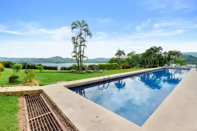 a swimming pool with a view of the water at Ground-Floor Condo Near Beach & Marina by SPCR in Playa Flamingo
