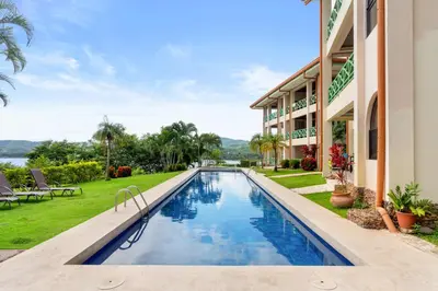 an image of a swimming pool in front of a building at Ground-Floor Condo Near Beach & Marina by SPCR in Playa Flamingo
