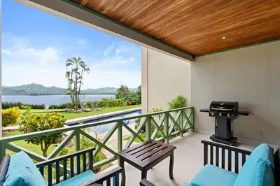 a balcony with a grill and a view of the water at Ground-Floor Condo Near Beach & Marina by SPCR in Playa Flamingo