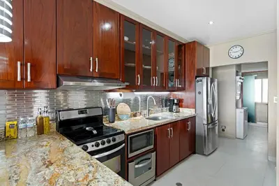 a kitchen with wooden cabinets and stainless steel appliances at Ground-Floor Condo Near Beach & Marina by SPCR in Playa Flamingo