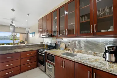 a kitchen with wooden cabinets and a sink at Ground-Floor Condo Near Beach & Marina by SPCR in Playa Flamingo