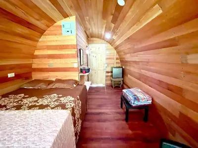 a room with a bed and a tv in a cabin at Gamboa Farm Lodge in Río Cuarto