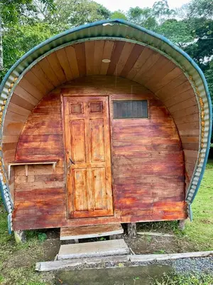 a large wooden shed with a door in the middle at Gamboa Farm Lodge in Río Cuarto