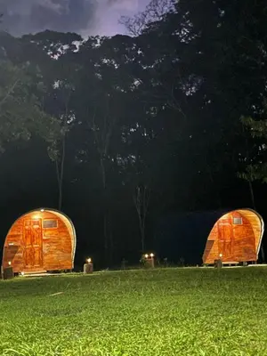 two wooden tents in a field at night at Gamboa Farm Lodge in Río Cuarto