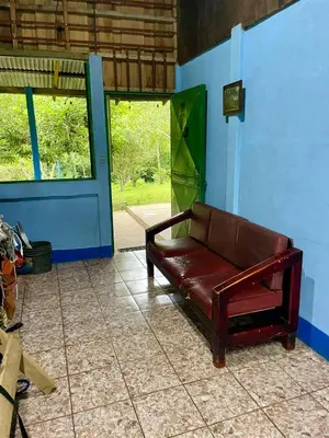 a brown couch sitting in the corner of a room at Gamboa Farm Lodge in Río Cuarto