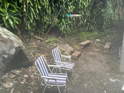 two chairs and a bench in a yard at La casa de la piedra in Monteverde Costa Rica