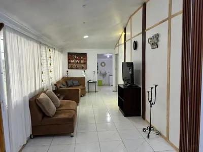 a living room with two couches and a television at La casa de la piedra in Monteverde Costa Rica