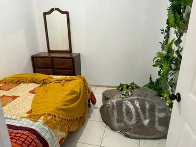 a bedroom with a bed and a rock with the word love at La casa de la piedra in Monteverde Costa Rica