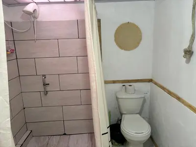 a small bathroom with a toilet and a shower at La casa de la piedra in Monteverde Costa Rica