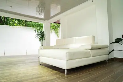 a white couch in a living room with wood floors at Home 333 Habitacion 331 in Escazu