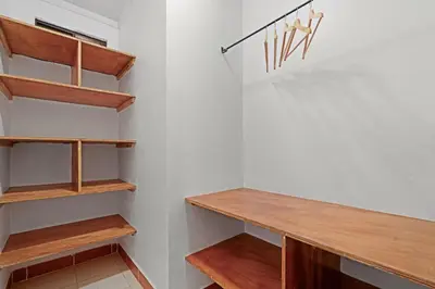 a walk in closet with wooden shelves at Villas Vibras in Playa Avellana