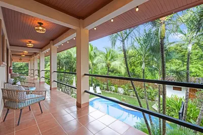 an indoor porch with a view of a pool and palm trees at Villas Vibras in Playa Avellana