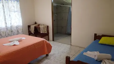 a bedroom with two beds and a walk in shower at CañoNegro CasaBlanca in Caño Negro