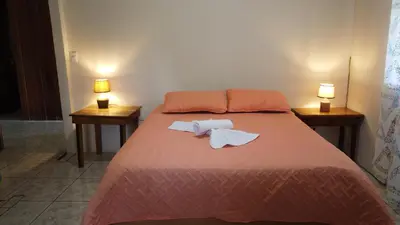 a bedroom with a bed with two nightstands and two lamps at CañoNegro CasaBlanca in Caño Negro