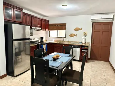 a kitchen with a table and a black refrigerator at Supreme Serenity 2BR2BA Ocotal Coastal Retreat in Coco
