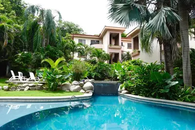a swimming pool in front of a house at Supreme Serenity 2BR2BA Ocotal Coastal Retreat in Coco
