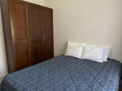 a bedroom with a bed with a pillow and a cabinet at Coastal Comfort Spacious Second-Floor Getaway in Coco