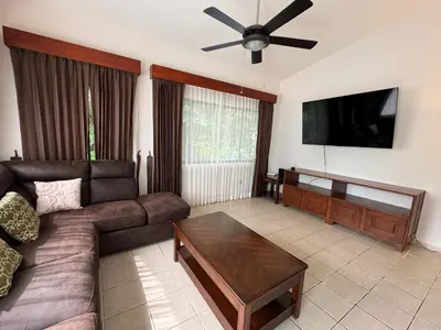 a living room with a couch and a flat screen tv at Coastal Comfort Spacious Second-Floor Getaway in Coco