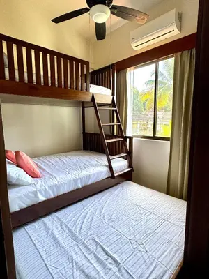 a bedroom with two bunk beds and a window at Coastal Comfort Spacious Second-Floor Getaway in Coco
