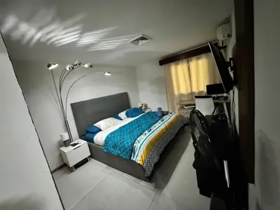 a bedroom with a bed with a blue blanket at Villa Ho Omaika I Los Delfines Tambor in Pochote