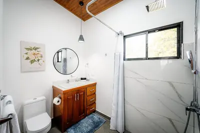 a bathroom with a toilet and a sink and a shower at Villas Santa Maria - Private Bay Lake Arenal in Nuevo Arenal