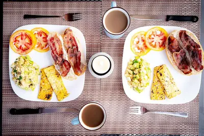 a plate of breakfast food with tomatoes and eggs at Villas Santa Maria - Private Bay Lake Arenal in Nuevo Arenal