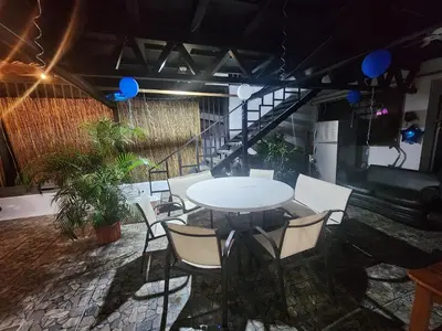 a table and chairs in a room with a staircase at Apartamento Casa Laura in Quepos
