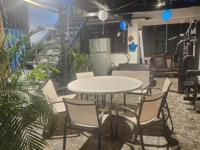 a table and chairs in a room with plants at Apartamento Casa Laura in Quepos