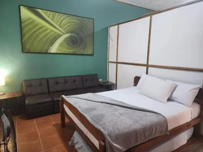 a bedroom with a bed and a couch at Apartamento Casa Laura in Quepos