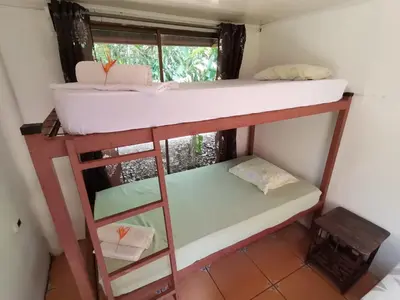 a room with two bunk beds and a window at Cabinas la Antorcha in Dominical
