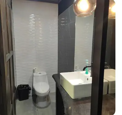 a bathroom with a white toilet and a sink at Cabinas la Antorcha in Dominical