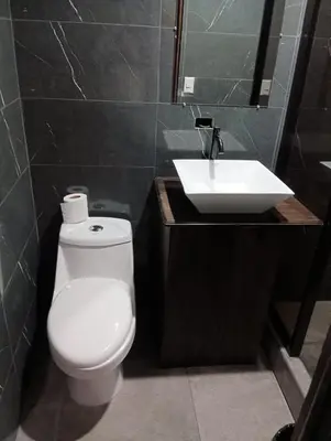 a bathroom with a white toilet and a sink at Cabinas la Antorcha in Dominical