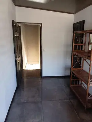 an empty room with a door and a shelf at Cabinas la Antorcha in Dominical