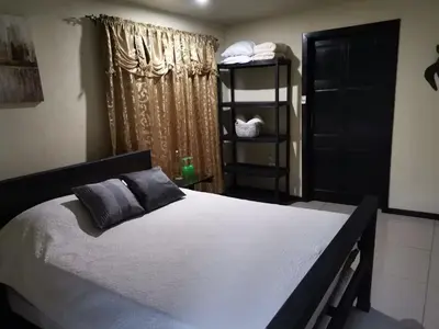 a bedroom with a large bed and a window at Cabinas la Antorcha in Dominical