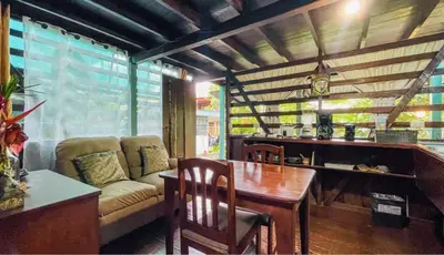 a living room with a couch and a table at Rustic wooden little house close to the beach in Uvita