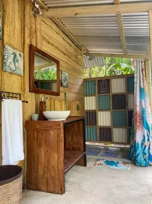 a bathroom with a sink and a mirror at Rustic wooden little house close to the beach in Uvita
