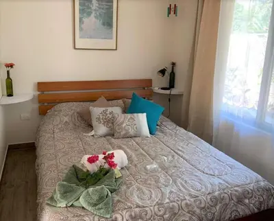 a bedroom with a bed with flowers on it at Cute studio-apartment near the beach in Uvita