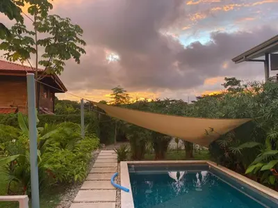 a hammock hanging over a pool in a backyard at Cute studio-apartment near the beach in Uvita