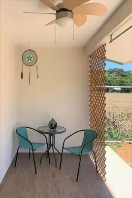 a patio with a table and two chairs and a ceiling fan at Cute studio-apartment near the beach in Uvita