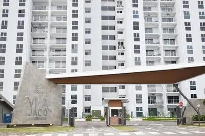 a large white building with a stop sign in front of it at Lulo Jaco New ocean view apartment in Jacó