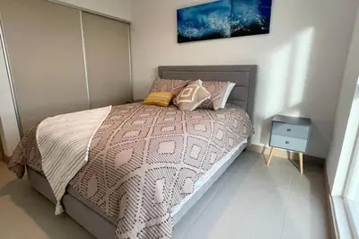 a bedroom with a bed and a night stand at Lulo Jaco New ocean view apartment in Jacó