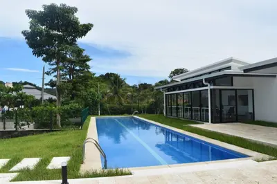 a swimming pool in front of a house at Lulo Jaco New ocean view apartment in Jacó
