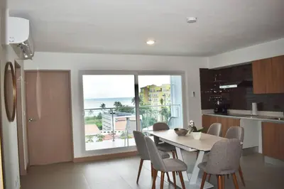 a kitchen and dining room with a table and a window at Lulo Jaco New ocean view apartment in Jacó