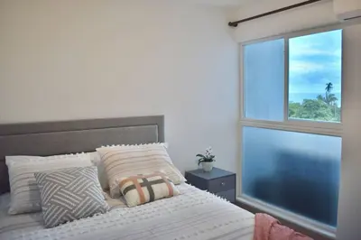 a bedroom with a bed with a window at Lulo Jaco New ocean view apartment in Jacó