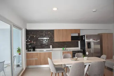 a kitchen with a table and chairs in a room at Lulo Jaco New ocean view apartment in Jacó