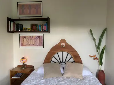a bed with two pillows on it in a room at Apartment with large terrace and garden view in Uvita